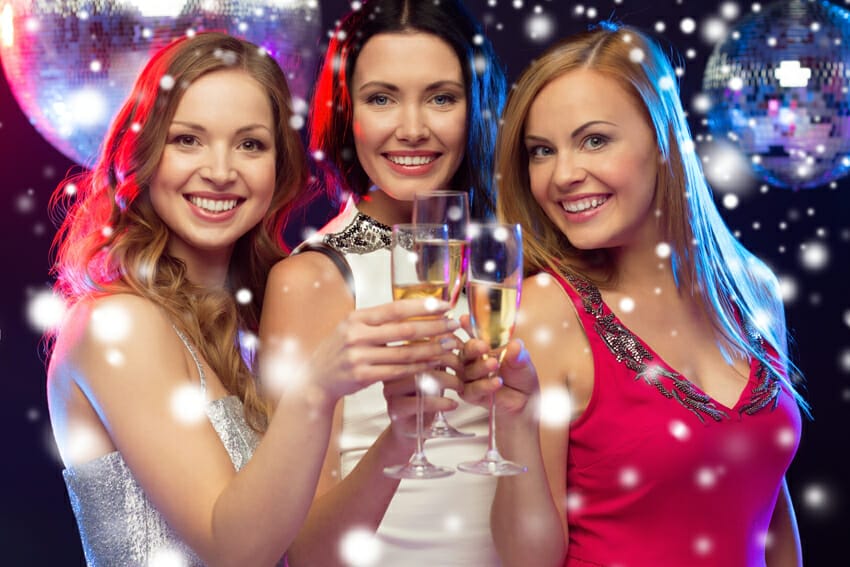 three smiling women with champagne glasses
