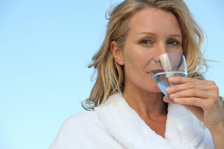 woman drinking water for skin