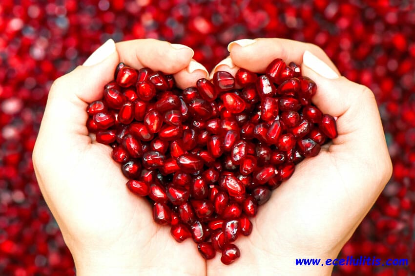 pomegranate seeds shaping heart in hands - sun protective food